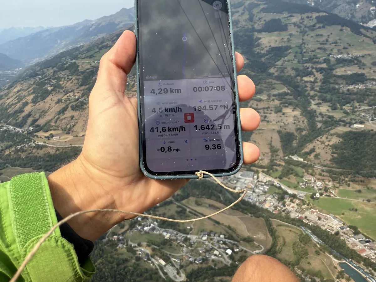 Wingman flight instruments on an iPhone, held in flight above an Alpine valley